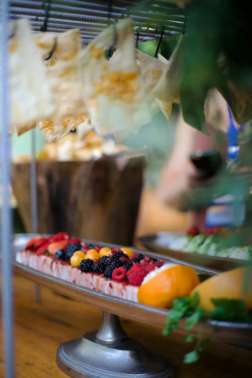 Bancada de frutas e sobremesas, com lâminas crocantes penduradas acima da mesa.